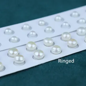 Macro detail of white freshwater pearls with natural threaded texture on white display