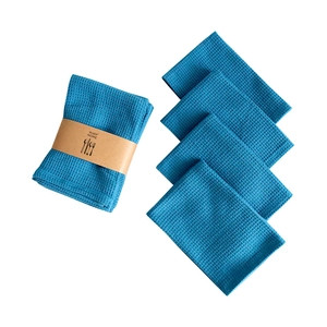 Ensemble de torchons de cuisine et serviettes en coton gaufré bleu avec emballage en papier.
