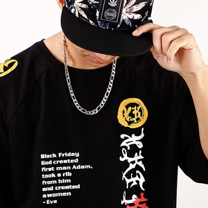 Détail d'un collier Figaro en acier inoxydable porté avec un t-shirt noir au style streetwear