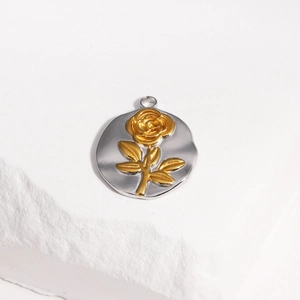 Détail d'un pendentif rond argenté avec relief de rose dorée 3D et anneau de fixation