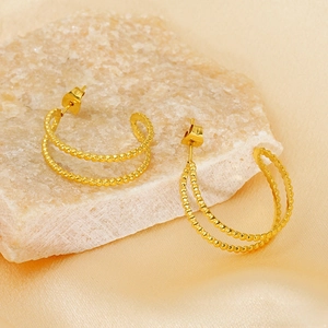 Detailed view of 18K gold plated double-row bead earrings on stone and silk