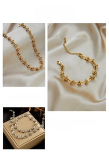 Detail of industrial style knotted chain necklace and bracelet in gold and silver finish