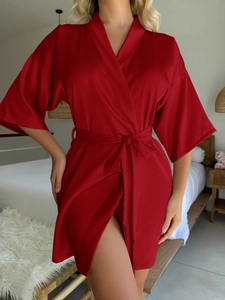 Détail de la texture satinée soyeuse et de la manche kimono du peignoir rouge foncé