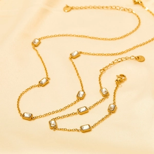 Golden stainless steel necklace with rectangular zircons on elegant beige silk fabric