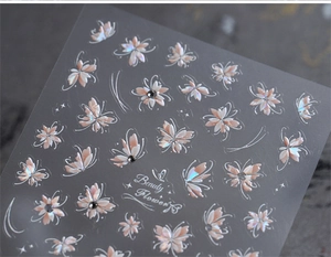 Detail of adhesive nail stickers with butterfly and flower patterns in pink and gold