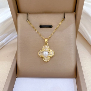 Detailed macro view of the gold-plated clover pendant with pearl and sparkling pavé crystals