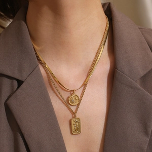 Detailed view of gold multi-layered necklace with star, moon and sun tarot pendants