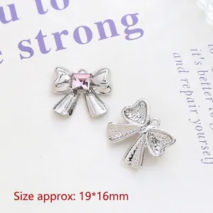 Detailed view of silver bow alloy pendant with pink square rhinestone and 19x16mm dimensions
