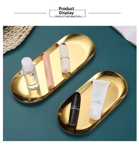 Macro view of two golden stainless steel oval trays for jewelry and makeup storage
