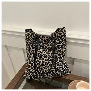 Close-up of leopard print canvas tote bag with slim black leather shoulder straps