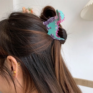 Close-up of a colorful dinosaur acrylic hair claw clip used in a brunette hairstyle