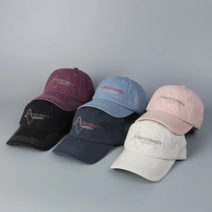 Detailed view of washed cotton baseball caps in various colors with embroidery