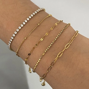 Five-piece set of gold and silver plated chain bracelets with rhinestones on model wrist