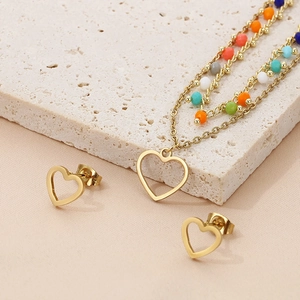 Detail of gold multilayer heart necklace and stud earrings set with colorful beads