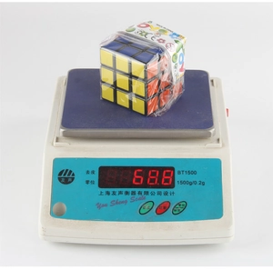 Detail showing the 3x3 educational magic cube being weighed at 68.8g on a digital scale