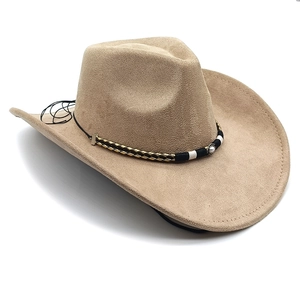 Detail of khaki suede cowboy hat featuring woven band and vintage faux pearl ornament