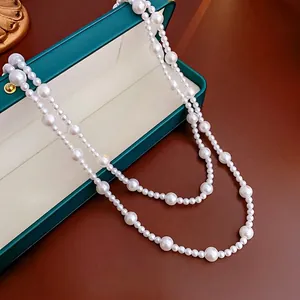 French vintage long pearl necklace displayed elegantly with a teal jewelry gift box