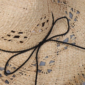 Handmade hollow straw sun hat for women with black bow and frayed wide brim design