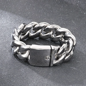 Macro shot of 25mm silver Cuban link bracelet with square clasp on grey stone