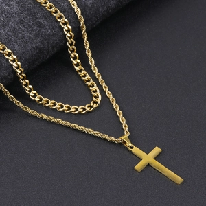Detail of gold double-layer cuban and twist chain with a minimalist cross pendant