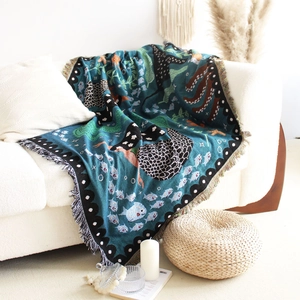 Close-up of bohemian mermaid knit throw blanket with fringe edge on a white sofa