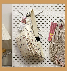Detail of cute dachshund cartoon print crossbody bag hanging on a white pegboard