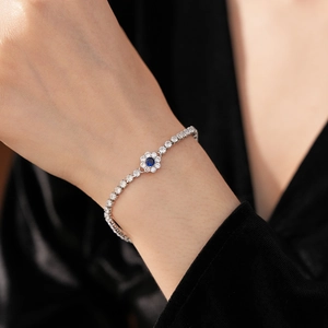 Close-up of a silver flower bracelet with a blue zircon center and sparkling white stones