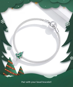 Detailed shot of silver mesh bracelet with green enamel Christmas tree charm and engraving