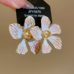 Macro shot of 925 silver floral heart stud earrings with pink enamel and gold accents