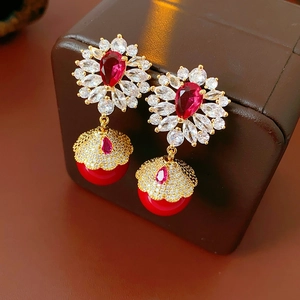 Détail de boucles d'oreilles vintage fleurs en zircon avec gouttes rouges sur boîte