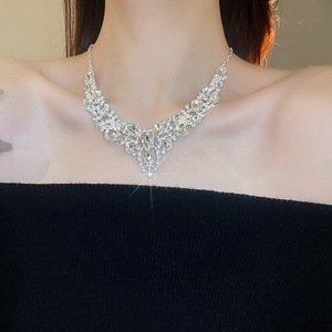 Close-up of sparkling V-shaped rhinestone teardrop necklace on model's neckline