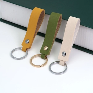 Close-up of PU leather keychains in ginger, olive, and beige with premium metal rings