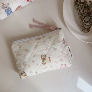 Detailed close-up of quilted floral mini pouch with dog pattern and zipper detail