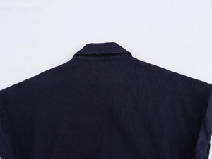 Détail macro du col et de la couture d'épaule sur une robe midi en denim bleu foncé