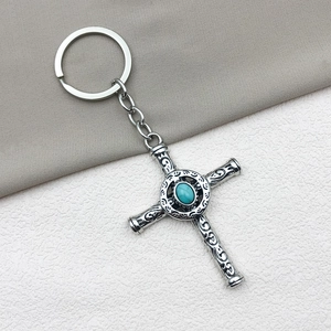Detailed silver cross pendant keychain featuring a turquoise gemstone and engraved metal