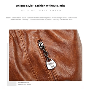 Detail of orange lychee grain leather bag with metal zipper and kangaroo logo tag