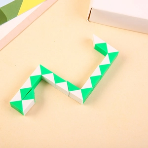 Detail shot of green and white 24-segment magic snake puzzle on a textured table