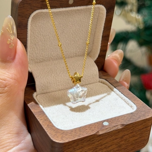 Vue détaillée d'un collier pendentif perle étoile plaqué or dans un coffret cadeau en bois