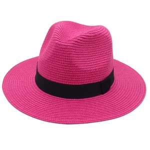 Detail of rose red woven Panama hat with black ribbon and spiral straw texture