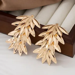 Goldene mehrlagige Weidenblatt-Ohrringe an einem hochwertigen Schmuckständer aus Holz