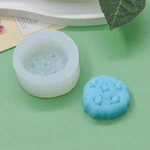 Detailed view of cylindrical silicone mold with star pattern and blue finished candle
