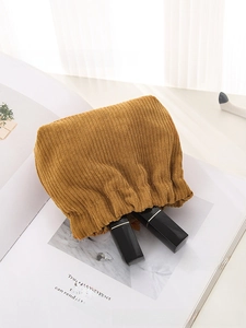 Brown corduroy squeeze pouch showing interior space with two lipsticks inside