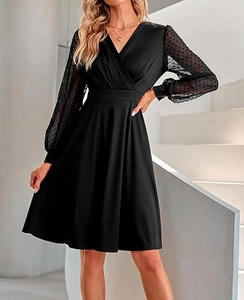 Detail of V-neck black dress with mesh polka dot long sleeves and cinched waistline