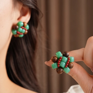 Detail of beaded square earrings featuring green jade and dark brown wood beads