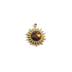 Detailed close-up of a 14K gold sun pendant with a faceted brown gemstone on white background