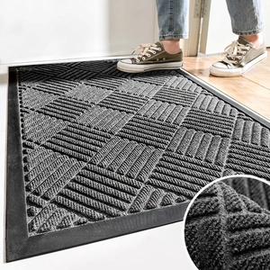 Dark gray geometric rubber door mat with non-slip texture on light wood floor