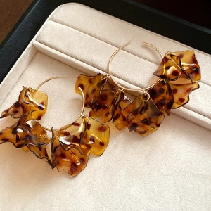 Detail of leopard print petal earrings with amber resin finish in a jewelry box