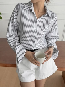 Detail of a casual long-sleeve striped shirt featuring a button-down design and clean cuffs