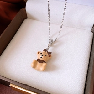 Macro view of light brown bear pendant necklace with silver chain in a jewelry box