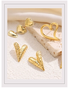 Detailed view of gold heart earring set with hammered texture and openwork designs